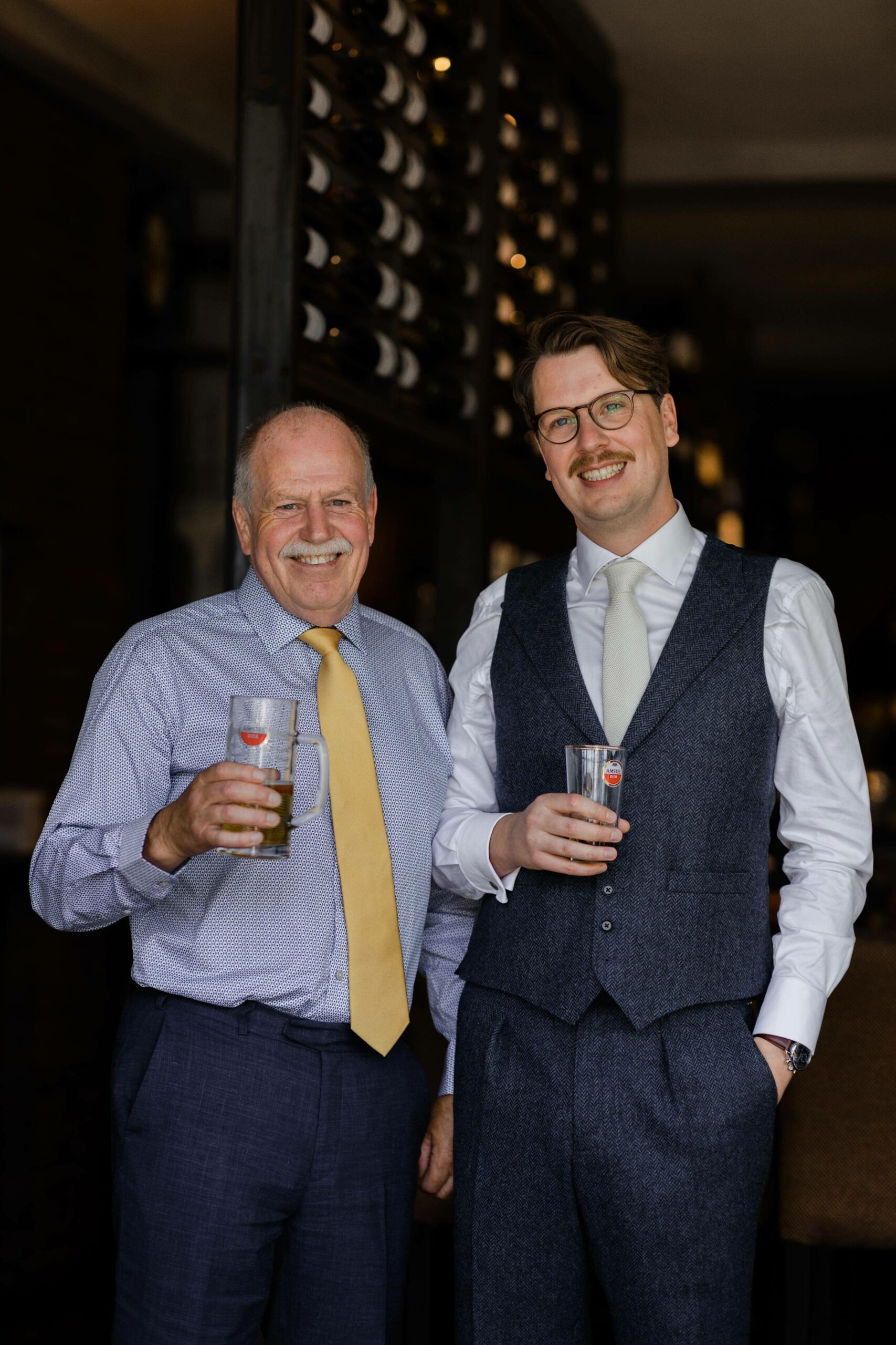 alt="summer Amsterdam wedding groom with father enjoying beers"